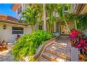 Lush landscaping surrounds the inviting front entrance with stone steps leading to the front door at 903 Pinellas Bayway S # 103, Tierra Verde, FL 33715