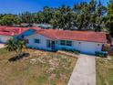 Aerial view showcasing the red tile roof, long driveway, and landscaping surrounding this cozy single-story home at 9952 111Th St, Seminole, FL 33772