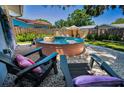 Inviting backyard featuring a unique stock tank pool, lounge chairs, privacy fence, and a charming pebble landscape at 9952 111Th St, Seminole, FL 33772