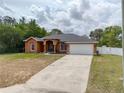 Charming single-story home with a two-car garage, arched entryway, and a spacious concrete driveway at 3234 Morven Dr, Spring Hill, FL 34609