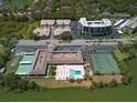 Aerial view of the community with a swimming pool and tennis courts on the lake at 10038 62Nd N Ter # 17, St Petersburg, FL 33708
