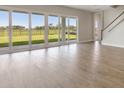 Bright and open living area with wood flooring, large sliding glass doors, and lots of natural light at 10320 Longmeadow Ave, Parrish, FL 34219