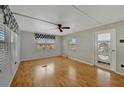 A bright bedroom featuring wood-look flooring and neutral walls, with a view to the exterior at 104 E Saint Johns Way, Apollo Beach, FL 33572