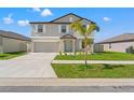 Charming two-story home with a well-manicured lawn, a concrete driveway, and a two-car garage at 11508 Sage Canyon Dr, Riverview, FL 33578
