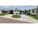 Charming single-story home featuring a well-maintained lawn, palm trees, and a paved driveway at 134 W Saint Annes Cir, Apollo Beach, FL 33572