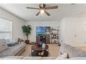 Inviting living room with plush seating, a modern entertainment center, and ample natural light at 13765 Whiskey Daisy Dr, Dade City, FL 33525