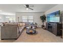 Cozy living room featuring a comfortable sofa, entertainment center, and a bright window at 13765 Whiskey Daisy Dr, Dade City, FL 33525