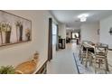 Inviting entryway with view to the dining area and modern decor touches create a warm welcome at 1398 Crescent Hoop Way, Wesley Chapel, FL 33543
