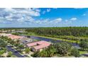 Aerial view of houses with red roofs along a lakefront community with mature trees at 15860 Aurora Lake Cir, Wimauma, FL 33598