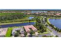 Beautiful community featuring a home with a red tile roof surrounded by lakes and lush greenery at 15860 Aurora Lake Cir, Wimauma, FL 33598