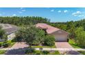 Beautiful single-story home with brick driveway and lush landscaping under a sunny sky at 15860 Aurora Lake Cir, Wimauma, FL 33598