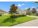Well-kept house boasts a vibrant green lawn, trimmed shrubs, and a tidy landscape design at 17668 Bright Wheat Dr, Lithia, FL 33547