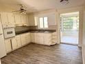 Functional kitchen with white cabinets, tiled backsplash, and abundant natural light at 2271 Terrace N Dr, Clearwater, FL 33765