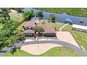 Aerial view of property featuring a large, landscaped lot with waterfront access, pool, and brick driveway at 2309 Cypress Walk Way, Ruskin, FL 33570