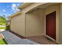 The home's red front door adds a touch of warmth and curb appeal to the exterior at 26338 Whirlaway Ter, Wesley Chapel, FL 33544