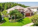 A single-story house features a stone facade, three-car garage, and meticulous landscaping for curb appeal at 29118 Picana Ln, Wesley Chapel, FL 33543