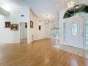 Open-concept living room with wood floors, high ceilings, and an arched window, providing a spacious and airy feel at 2973 Spring Oak Ct, Palm Harbor, FL 34684