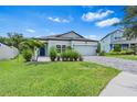 Charming single-story home with a well-manicured lawn and a brick-paved driveway at 30801 Parrot Reef Ct, Wesley Chapel, FL 33545