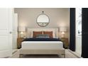 Tastefully decorated bedroom with a neatly made bed, side tables, and a decorative round mirror at 3436 Lapis Lake Dr, Zephyrhills, FL 33541