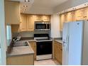 Well-maintained kitchen featuring light wood cabinets, updated appliances, and granite countertops at 400 Island Way # 1402, Clearwater Beach, FL 33767