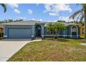 Single-story blue home with well-maintained landscaping, garage and palm trees at 4612 35Th E Ave, Palmetto, FL 34221