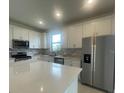 Modern kitchen with stainless steel appliances, white cabinetry, quartz countertops, and lots of natural light at 5014 Coastal Oak Ct, Lakewood Ranch, FL 34211