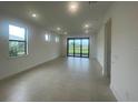 Open concept living room featuring neutral paint, tile floors, large windows, and sliding door access to outdoors at 5014 Coastal Oak Ct, Lakewood Ranch, FL 34211