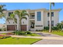 Elegant two-story home showcasing lush landscaping, a three-car garage, and a welcoming front entrance at 5110 W Longfellow Ave, Tampa, FL 33629