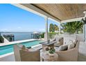Covered outdoor patio with comfortable seating, an outdoor kitchen, and views of the pool and waterfront at 5110 W Longfellow Ave, Tampa, FL 33629