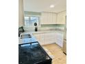 Bright kitchen with white cabinets, granite countertops, and stainless steel appliances at 5654 12Th St, Zephyrhills, FL 33542