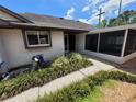 Welcoming front entrance featuring manicured greenery and a screened-in porch at 7125 Silvermill Dr, Tampa, FL 33635