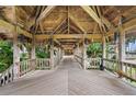 Wooden walkway with tropical foliage leading to the building's entrance, offering an inviting and serene ambiance at 7600 Bayshore Dr # 1201A, Treasure Island, FL 33706