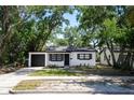 Well-maintained single-story home features modern black and white design, attached garage, and fresh landscaping at 8059 26Th N Ave, St Petersburg, FL 33710