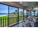 Enclosed patio offers stunning views of the lush lawn, beach, and bay from comfortable seating areas at 865 S Gulfview Blvd # 202, Clearwater Beach, FL 33767
