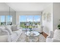 Bright living room with hardwood floors and sliding glass doors to the balcony at 9000 Commodore Dr # 606, Seminole, FL 33776