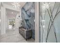 Bright foyer featuring luxury vinyl flooring, a modern bench, and a distinctive, decorative light fixture at 10381 Tupper Cay Dr, San Antonio, FL 33576
