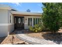Charming front entrance with a decorative door, manicured landscaping, and a welcoming walkway at 10875 131St St, Largo, FL 33774