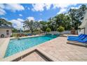 Inviting backyard pool area featuring a relaxing lounge area, landscaping, and tiled patio at 10875 131St St, Largo, FL 33774