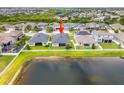 Aerial view of a home with a large backyard and a serene lake, surrounded by a white picket fence at 11522 Sunburst Marble Rd, Riverview, FL 33579