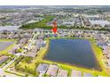 An aerial view of a suburban neighborhood featuring a scenic lake and well-maintained homes at 11522 Sunburst Marble Rd, Riverview, FL 33579