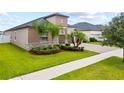 Beautiful single-Gathering home showcasing manicured landscaping with palm trees and a spacious paved driveway at 11522 Sunburst Marble Rd, Riverview, FL 33579