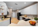 Bright kitchen with white cabinets, a black appliance suite, and a double basin sink set into light countertops at 11559 Captiva Kay Dr, Riverview, FL 33569