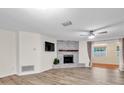 Cozy living room with a brick fireplace, wood-look floors, and neutral paint, creating a warm and inviting atmosphere at 12946 116Th St, Largo, FL 33778