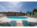 Backyard pool area with sun loungers, patio, and a pristine in-ground pool, perfect for relaxation and outdoor enjoyment at 12946 116Th St, Largo, FL 33778
