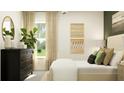 Bright bedroom boasting ample natural light, a sleek dark dresser, and minimalist wall art at 13126 Empress Jewel Trl, Parrish, FL 34219