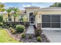 Inviting home entrance with well-kept landscaping and a screened garage at 13238 Chipout Ln, Hudson, FL 34669