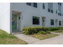 Modern townhome featuring a light-colored exterior, green door with wreath, and manicured landscaping at 1330 W Gray St # 1, Tampa, FL 33606