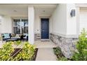 Covered front porch with an outdoor seating area and a blue front door at 1675 Bering Rd, Wesley Chapel, FL 33543