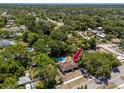 Aerial view of property showing the house, pool, and surrounding mature trees at 1683 Pine St, Largo, FL 33774