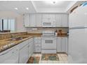 Well-maintained kitchen with granite countertops, white appliances, and ample cabinet space at 17710 Gulf Blvd # 304, Redington Shores, FL 33708